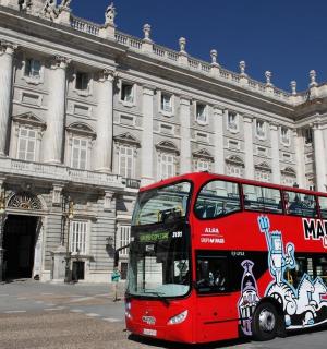 一辆红色双层巴士停在一栋建筑物前