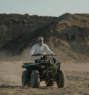 一名男子在沙漠中驾驶四轮车