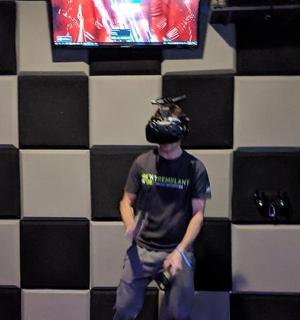 човек стоји испред зида са телевизором