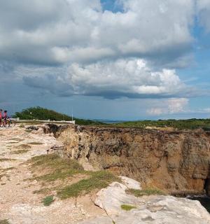 两个人在灯塔旁的悬崖上骑自行车