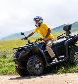 一名男子在土路上骑着四轮摩托车