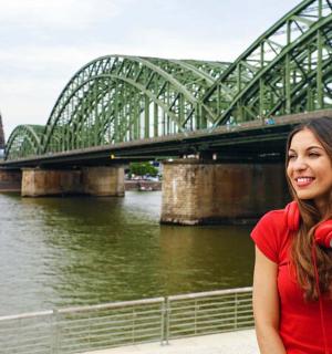 eine Frau steht vor einer Brücke