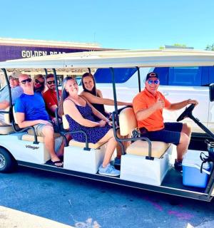 一群人坐在高尔夫球车里