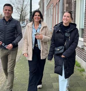 two men and a woman walking down the street