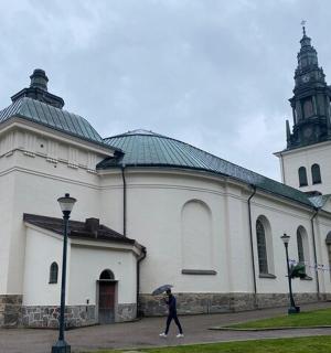 osoba kráčející před bílým kostelem