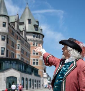 a man wearing a hat standing in front of a castle
