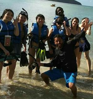 Un grupo de personas de pie en el agua en una playa.