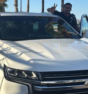 a man standing in the back of a white truck