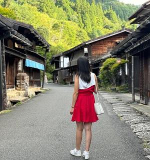 a woman in a red dress walking down a street