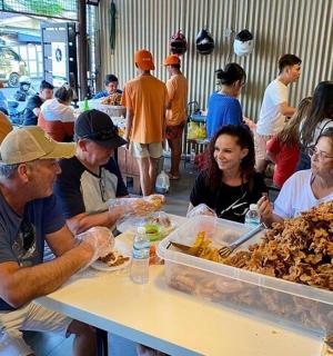 um grupo de pessoas sentadas à mesa comendo comida