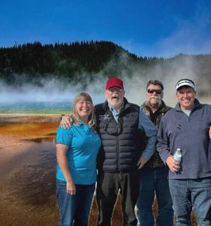 一群人在间歇泉前摆姿势拍照