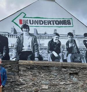 muž stojící před zdí s nástěnnou malbou