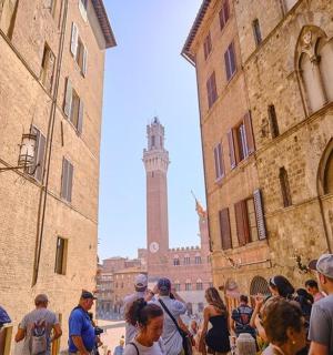 a crowd of people standing in a street with a clock tower