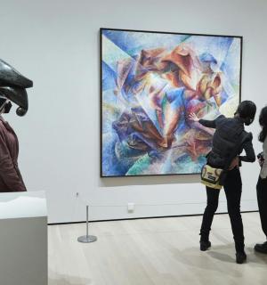 un grup de persones mirant una pintura en un museu