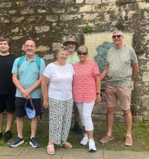 a group of people standing in front of a stone wall