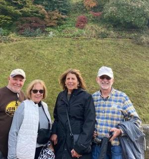 a group of people posing for a picture in front of a hill
