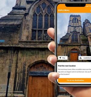 a person holding up a cell phone in front of a church