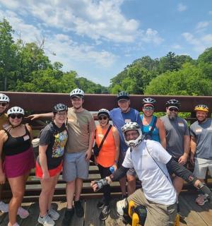 eine Gruppe von Menschen, die auf einer Brücke für ein Foto posieren