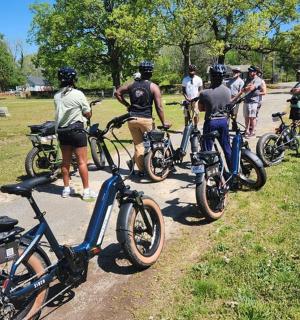 eine Gruppe von Menschen steht mit Fahrrädern auf einem Weg