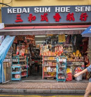 一男一女撑着伞走过一家商店