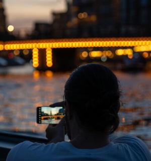 一位女士用手机拍摄河流