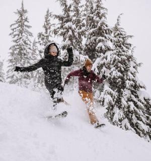 two people are skiing down a snow covered slope