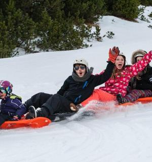 a group of people sitting in the snow on snowboards