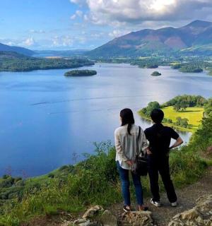 两个人站在山顶俯瞰湖泊