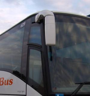 一辆大型巴士停在一栋建筑旁边