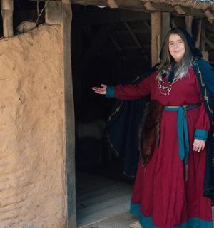 一位身穿红裙的女子站在一栋建筑外