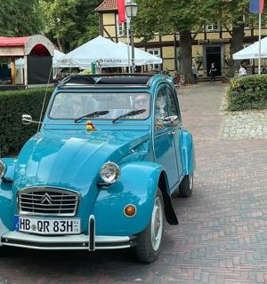a blue car parked on a brick road