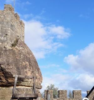 一座城堡，旁边有一块岩石，旁边有一张木凳