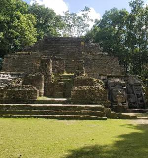 a temple in a field with grass and trees