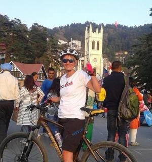 一名男子站在人群中,推着自行车