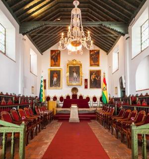 an empty church with red chairs and a chandelier