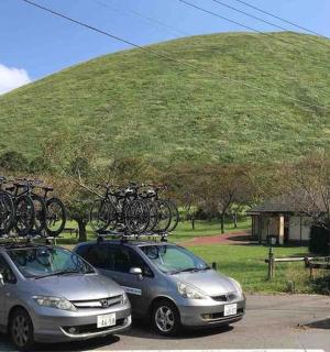 两辆汽车停在停车场,车顶上放着自行车