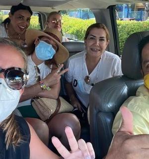 a group of people sitting in a car wearing masks