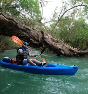 a man in a blue kayak on a river