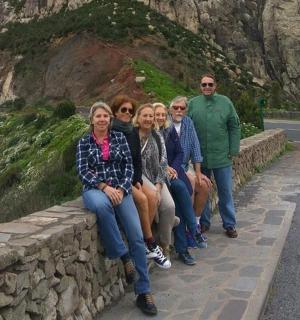 一群人坐在路边的墙上