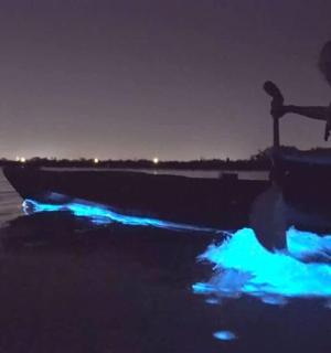 晚上，一名男子坐在海滩的船上