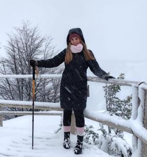 一名女子站在雪地上滑雪