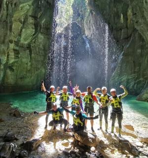 skupina lidí pózujících před vodopádem