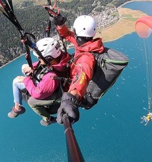 two people are parachuting over a body of water