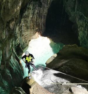 um homem está em pé em uma corda em uma caverna
