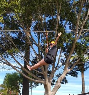 a woman is hanging on a rope in a tree