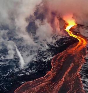 an aerial view of a volcano with lava and smoke