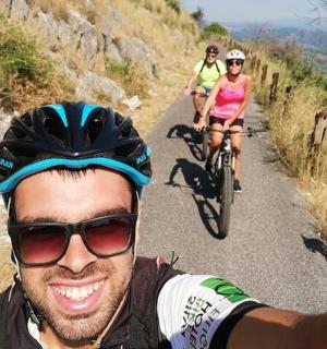 muž a dva lidé jedoucí na kolech po stezce