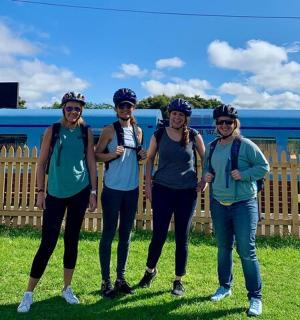 a group of women standing in front of a train