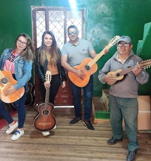 um grupo de pessoas em pé em uma sala segurando guitarras
