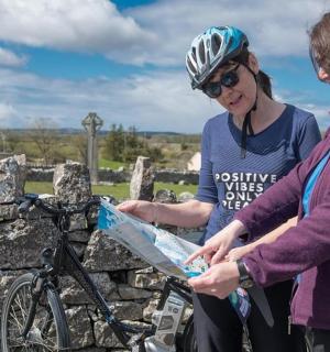 两名女子站在一辆自行车旁边